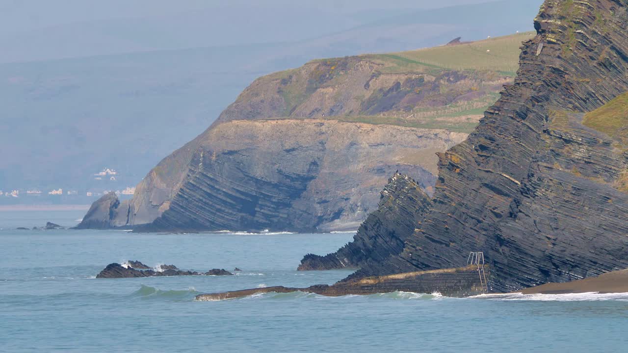 estratos rocosos inclinados en acantilados cerca de aberystwyth, ceredigion en gales occidental en la costa del mar de irlanda