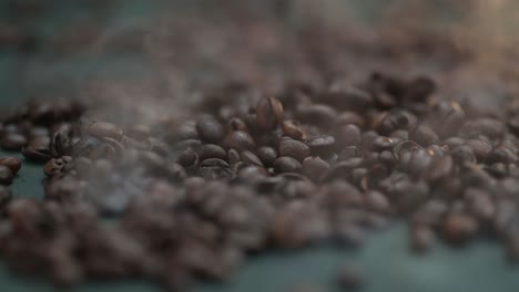 Close-up-time-lapse-of-coffee-beans-falling,-spilling-onto-the-table-in-smoke,-fog