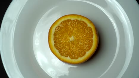 la fruta de naranja fresca está zoomando y girando en la placa blanca.