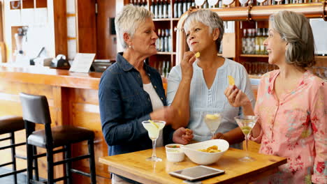 senior friends eating snacks while having cocktail 4k