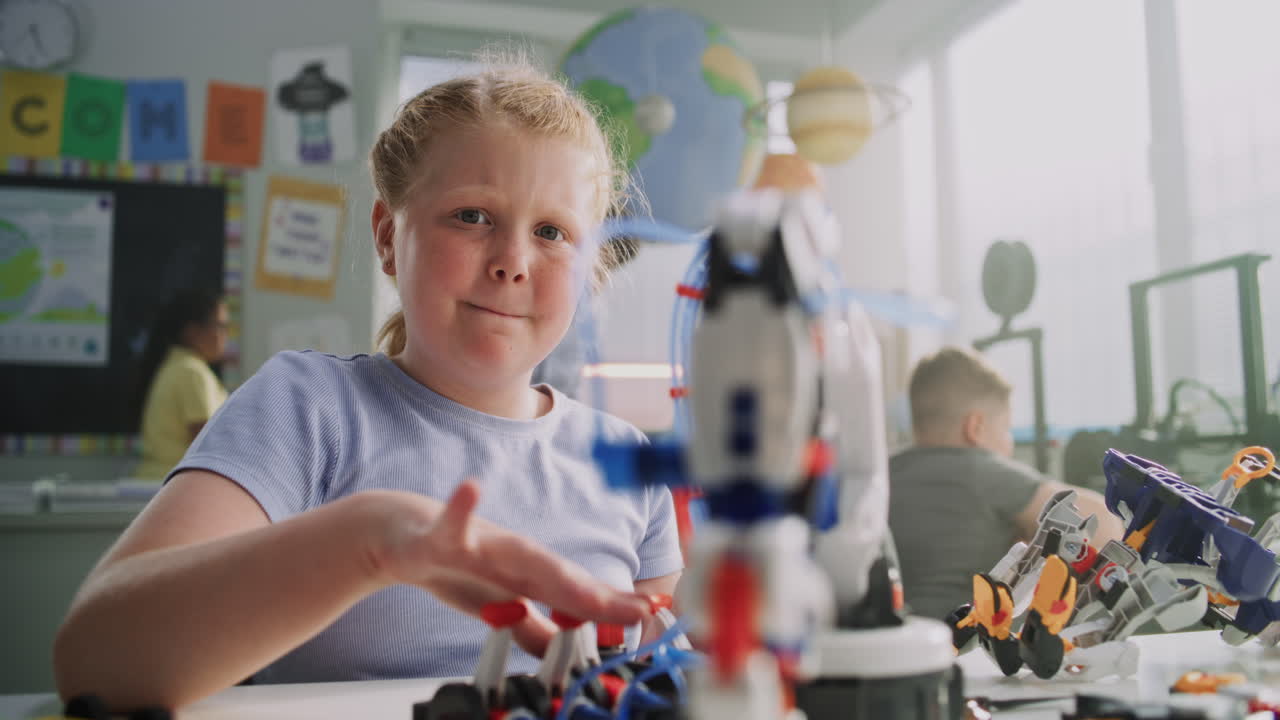 Elementary School Girl Sitting at Desk Doing Writing Tasks in School Notebook
