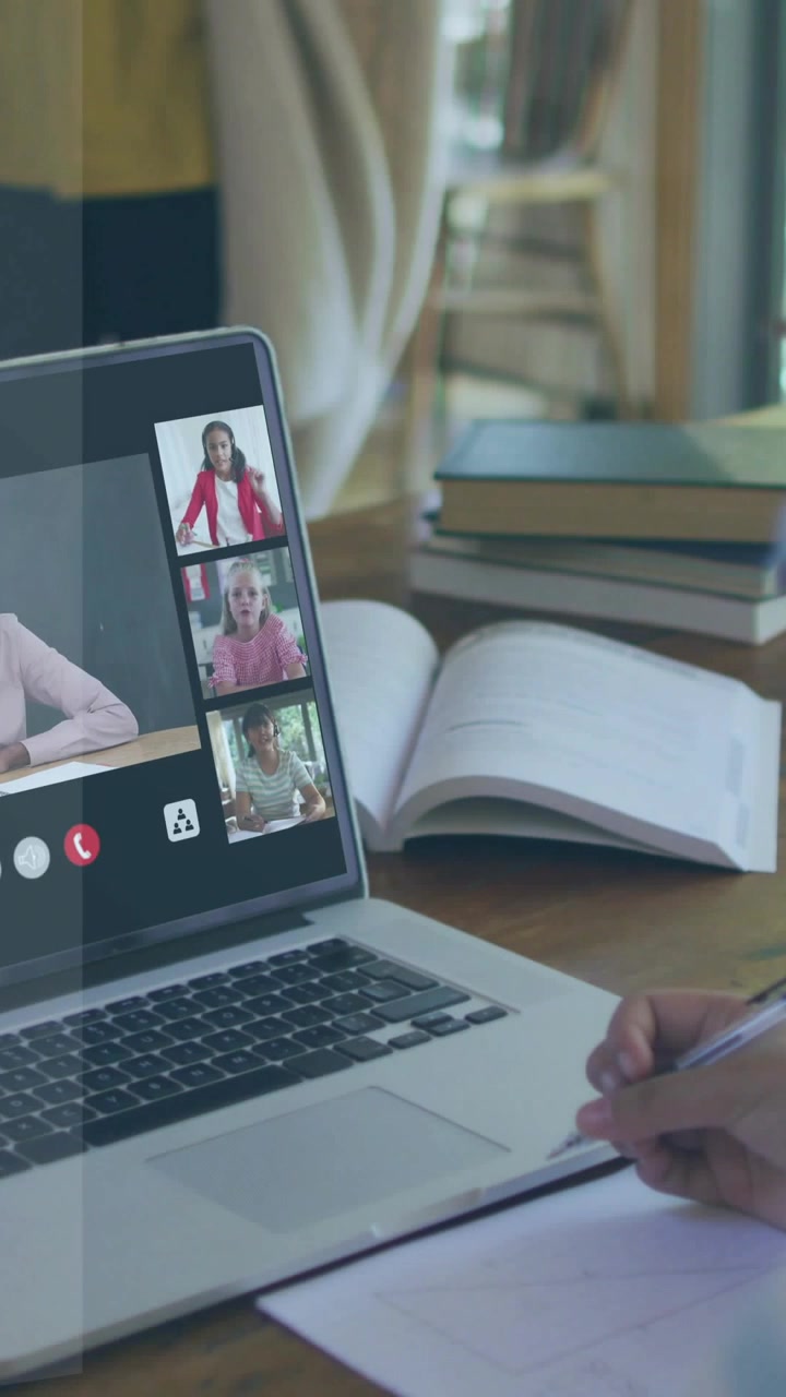 Video vertical: Profesor tomando notas en una llamada grupal, con gráficos superpuestos en la laptop que apoyan la educación