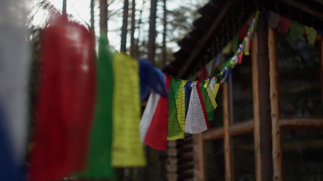 Sito di glamping tradizionale dell'Altai con bandiere colorate e capanna in legno ecologica. Concetto di turismo di montagna e viaggio autentico