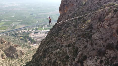 vía ferrata puente cruzado por mujer joven