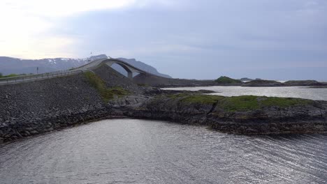 famous curvy storseisundet bridge along atlantic ocean road in coastal norway - static summer clip with motorcycle and car passing over bridge