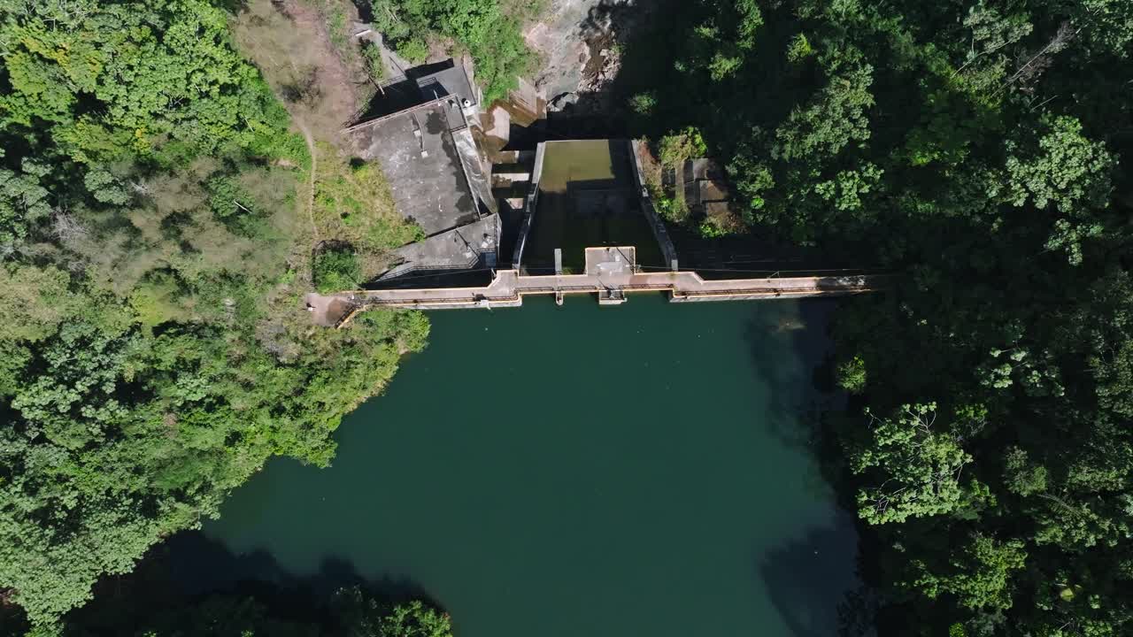 Aerial top down shot of tireo dam in Bonao during sunny day, surrounded by dense Mangrove plants