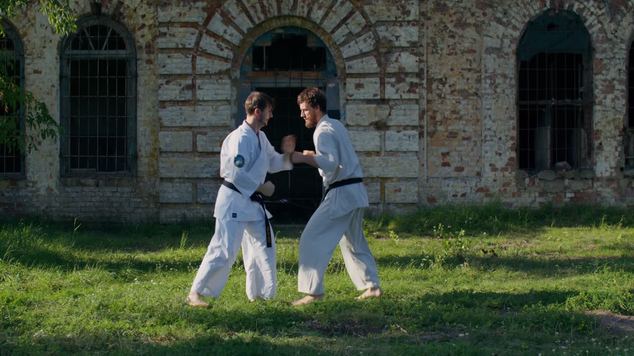 Due uomini che praticano karate all'aperto