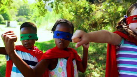 Friends-pretending-to-be-a-superhero-in-park