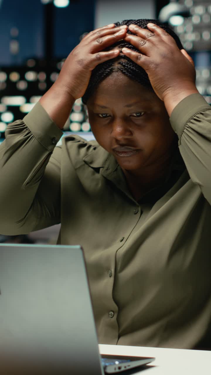 Vertical Video Black female assistant tensed and burdened in dark office after hours