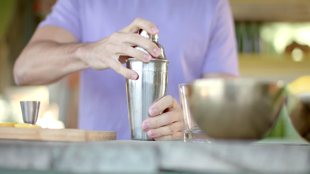 Primo piano di un barman caucasico che prepara cocktail in un bar sulla spiaggia.