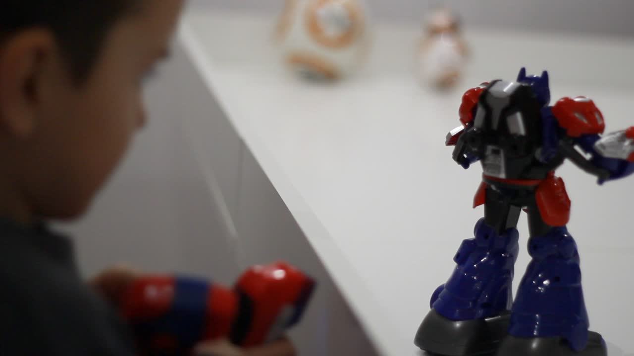 niño enciende juguete robot. robot y niño jugando. niño revisa juguete robot
