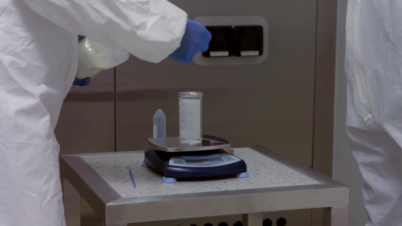 보호복을 입은 과학자들이 함께 일하고 있습니다.