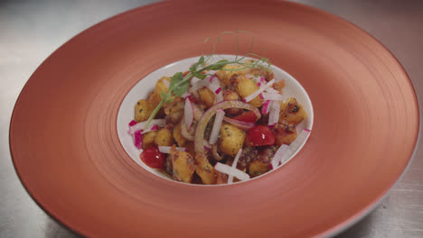 chef plating a delicious potato and vegetable salad
