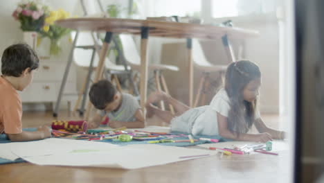 kids lying on floor and drawing pictures with colored pencils