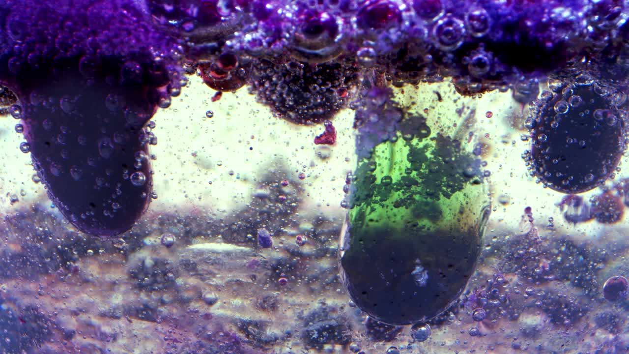 유리 뒤에 잉크가 있는 기름과 물에 있는 거품