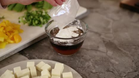 Woman-Pouring-Corn-Starch-Into-Bowl-To-Make-Sauce-In-Slow-Motion