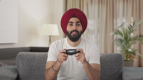 serious sikh indian man playing video games