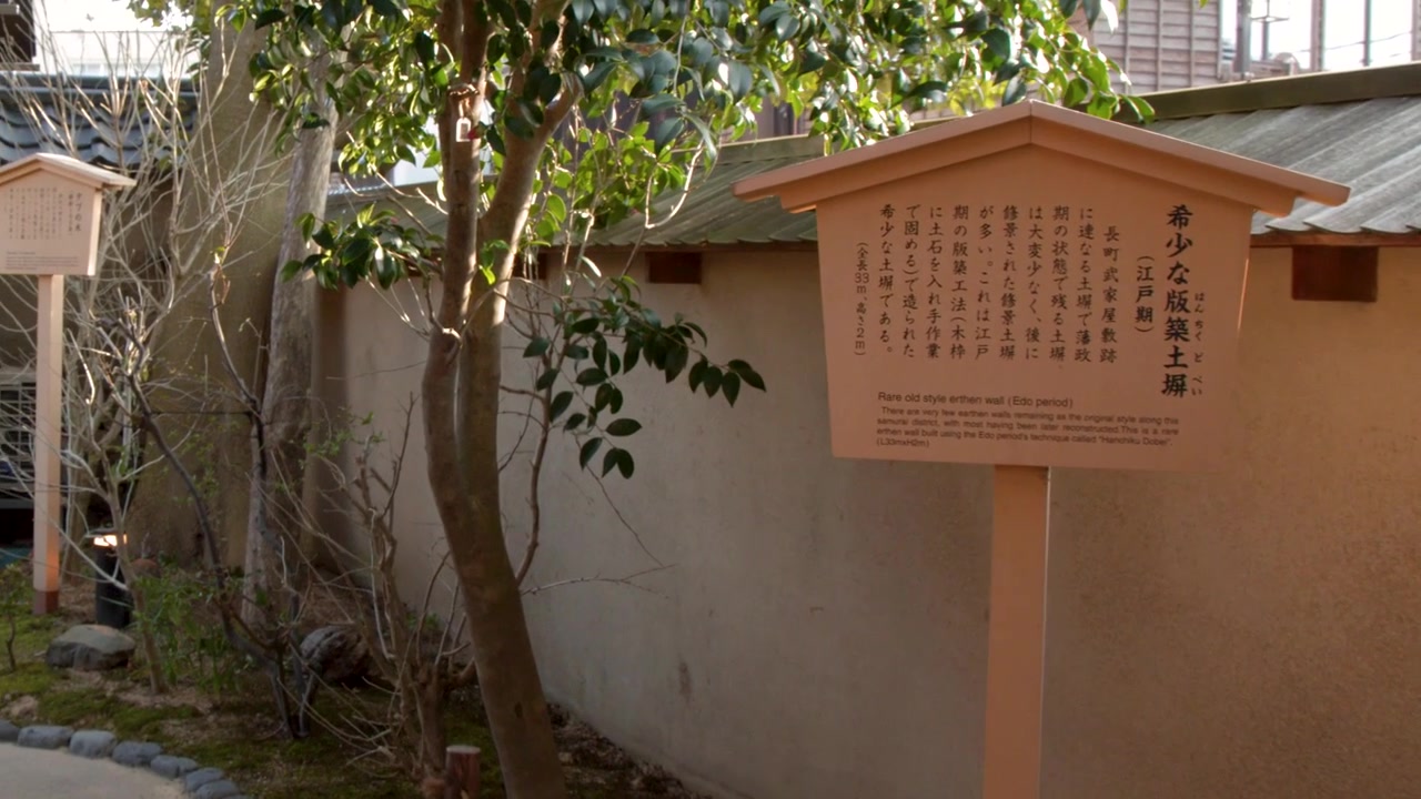 Một cảnh quay lia chậm cho thấy bức tường đất cổ kính và khu vườn ở Kanazawa, Nhật Bản.