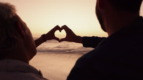 couple, heart and hands at beach in sunset