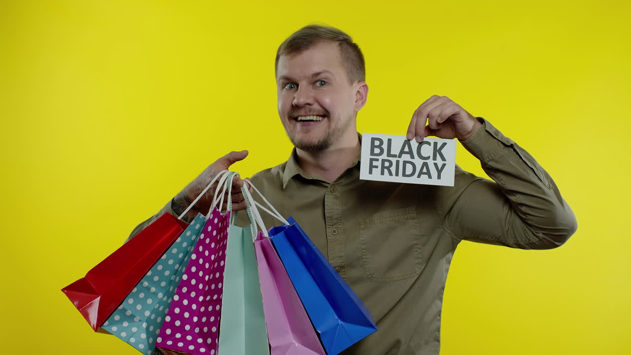 hombre feliz mostrando la inscripción del viernes negro, sonriendo, pareciendo satisfecho con los precios bajos. cámara lenta