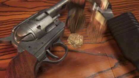 pièces d'or tombant sur du bois avec un pistolet et un couteau