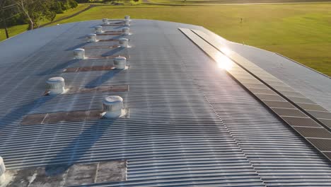 aerial footage of a roof with solar panels and ventilation systems, captured at sunset on the gold coast, australia