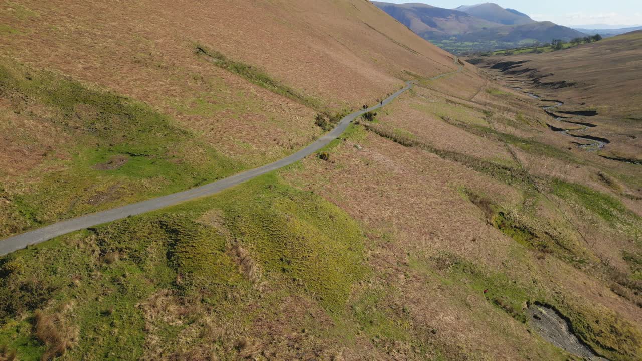 excursionistas lejanos en el camino de la ladera con la revelación del final del valle cerca de la mina force crag coledale beck en el distrito de los lagos ingleses