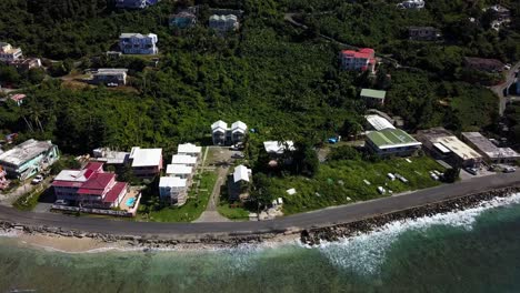 Acercamiento-Aéreo-Sobre-El-Agua-A-Los-Hogares-Locales-En-Una-Playa-Tortola-De-La-Isla-De-BVI