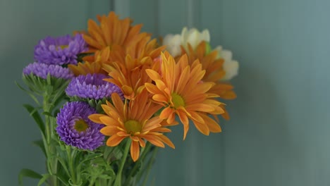 toma estática de un arreglo floral simple contra una pared azul pálido