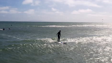 surfista en equilibrios de silueta para montar una ola en una tabla de surf - vista aérea líder