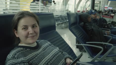 a woman in her 30s waits at an airport in dubai for a plane