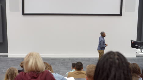 University-lecture-in-lecture-theatre,-back-row-student-POV