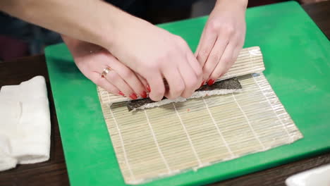 preparing sushi set. closeup of man chef putting japanese sushi rolls with rice
