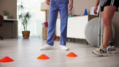 a woman with a prosthetic leg is doing physical therapy with a therapist in a gym.