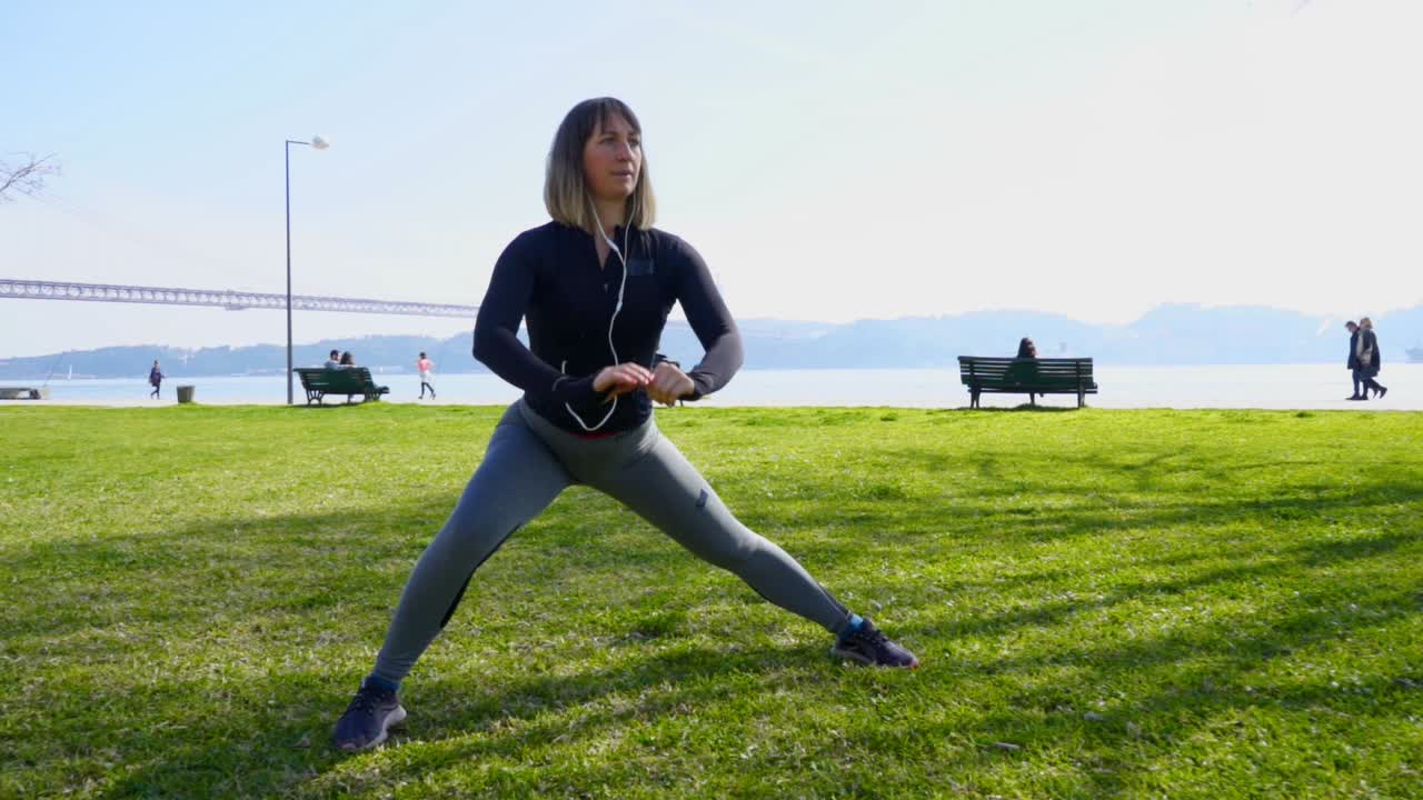 Concentrated sporty girl training on green lawn