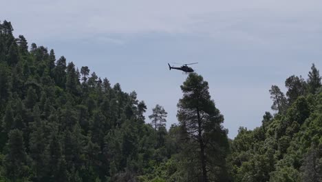 a helicopter delivers construction materials for wire mesh installation to prevent landslides in a remote and steep terrain. aerial logistics in action.