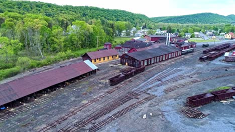 An-Aerial-View-of-an-Abandoned-Narrow-Gauge-Coal-Rail-Road-with-Rusting-Hoppers-and-Freight-Cars-and-Support-Building-Starting-to-be-Restored