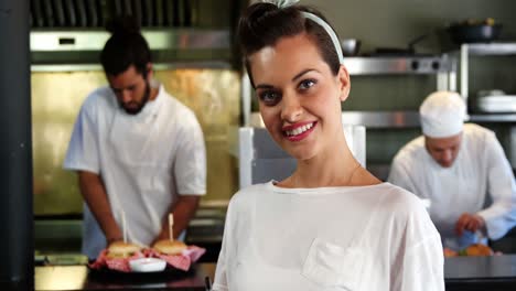 Happy-waitress-standing-in-kitchen