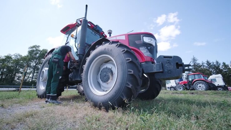 Farmer mechanic repairing tractor. Open tractor hood, engine. Repair agricultural technology