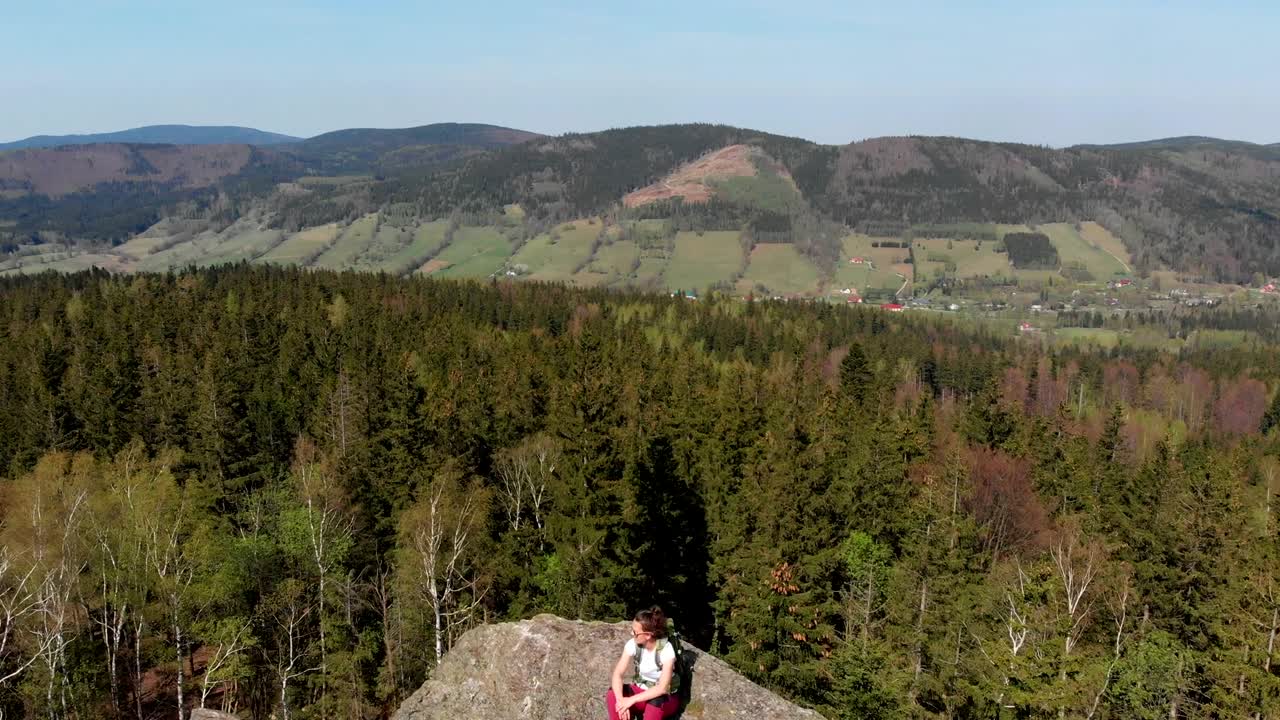 успешная молодая женщина с поднятыми руками на вершине горы.