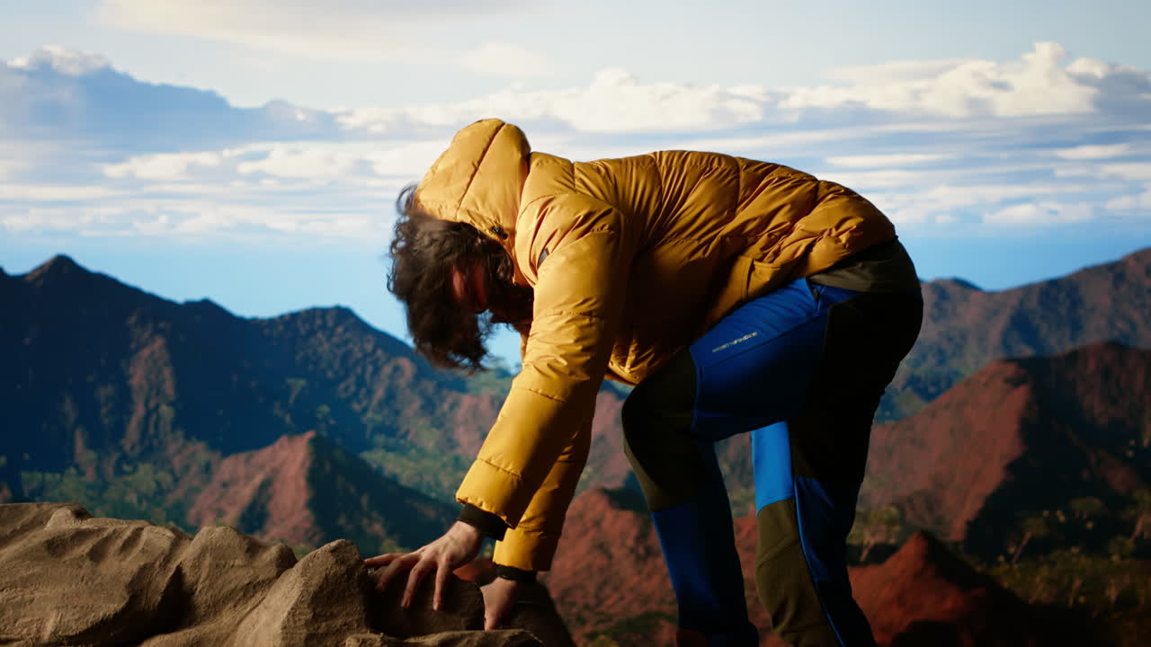 joven excursionista actuando imprudentemente distraído por el teléfono inteligente en la cima de la montaña