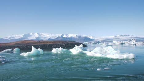 agua que fluye alrededor de icebergs en una laguna marina en islandia, costas rocosas