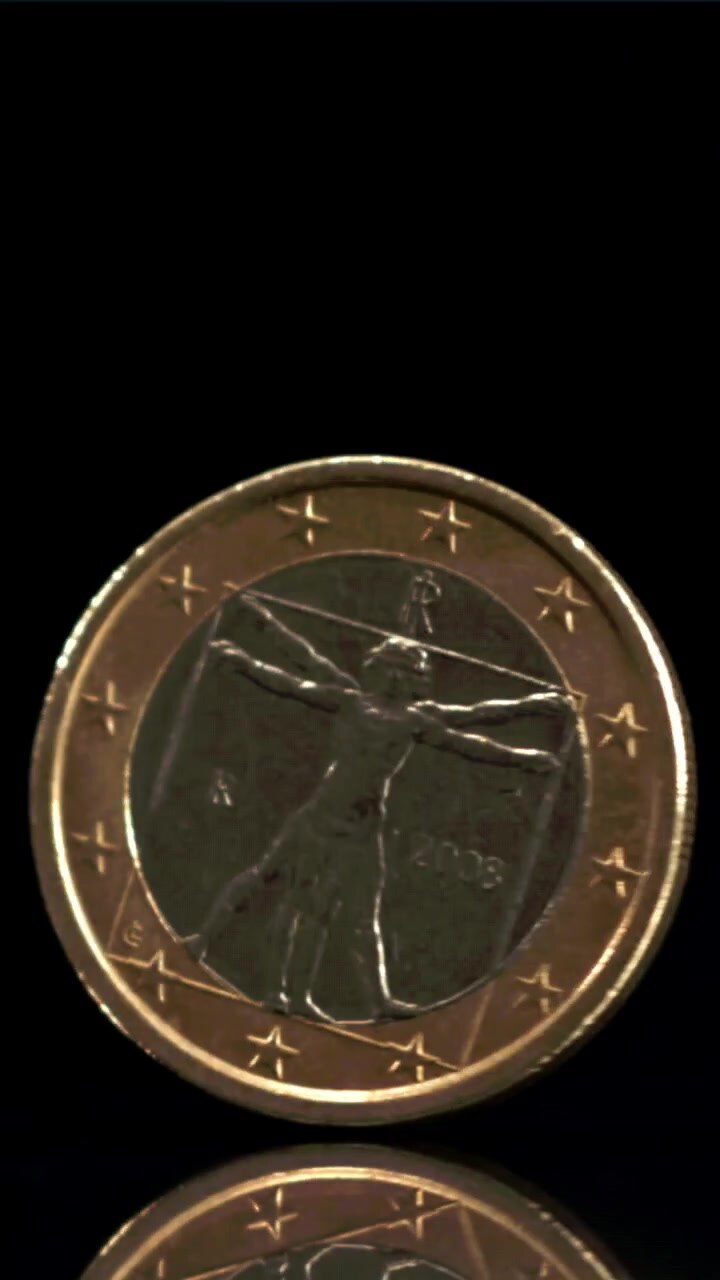 Moneta da un euro che gira su una superficie nera riflettente