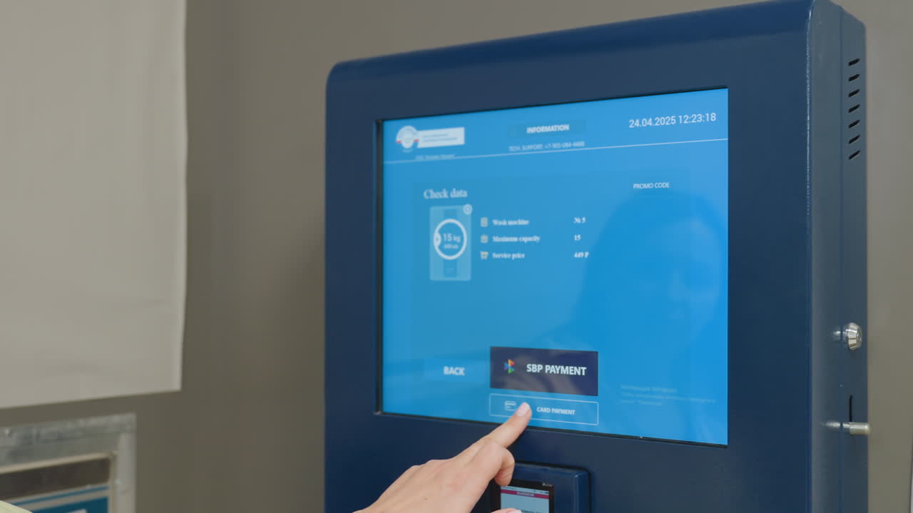 Close up of digital payment machine screen displaying payment options and service details, showing modern laundry technology interface with card and bank transfer methods for customer convenience