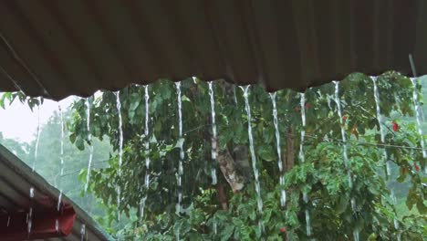 heavy rain streaming from a tin roof during a tropical storm, monsoon season in the philippines