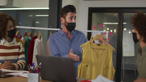 Mixed-race-clothes-designers-having-video-call-wearing-face-masks