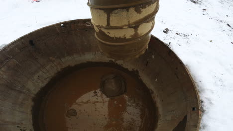 POV-Des-Bohrkopfes-Auf-Einem-Hydraulischen-Bohrgerät,-Das-Im-Winter-Ein-Loch-In-Den-Boden-Bohrt