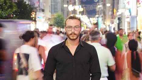 young man looking at camera in crowd. timelapse video.