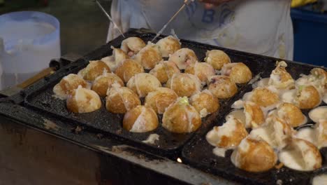 thailand night market street food booth cooking squid octopus cuttlefish ball in hot summer