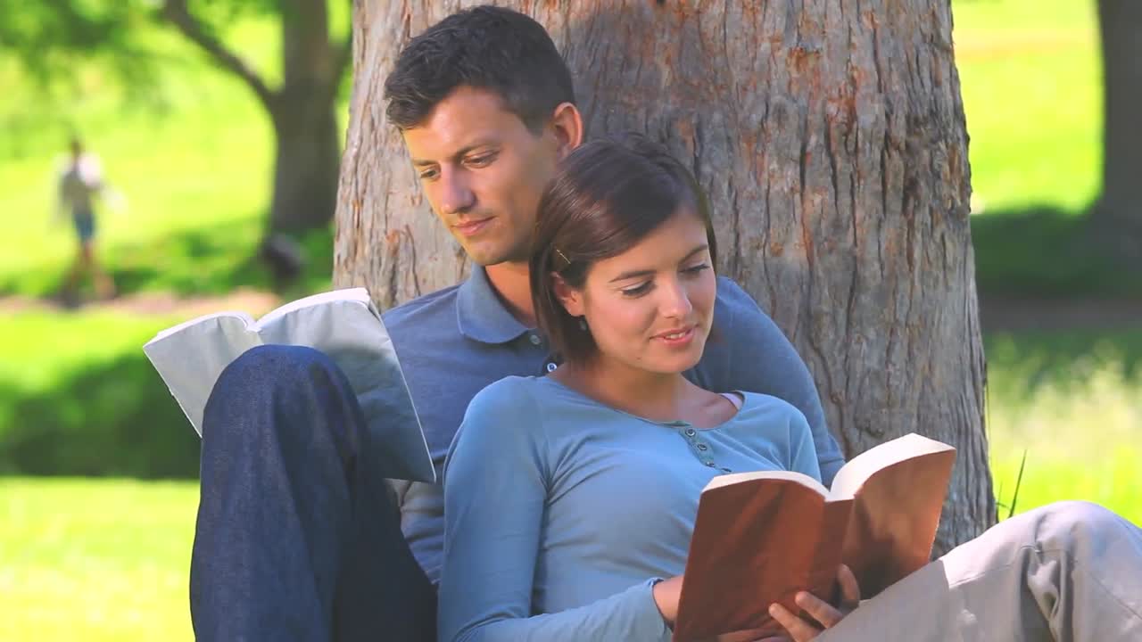 pareja joven leyendo al aire libre